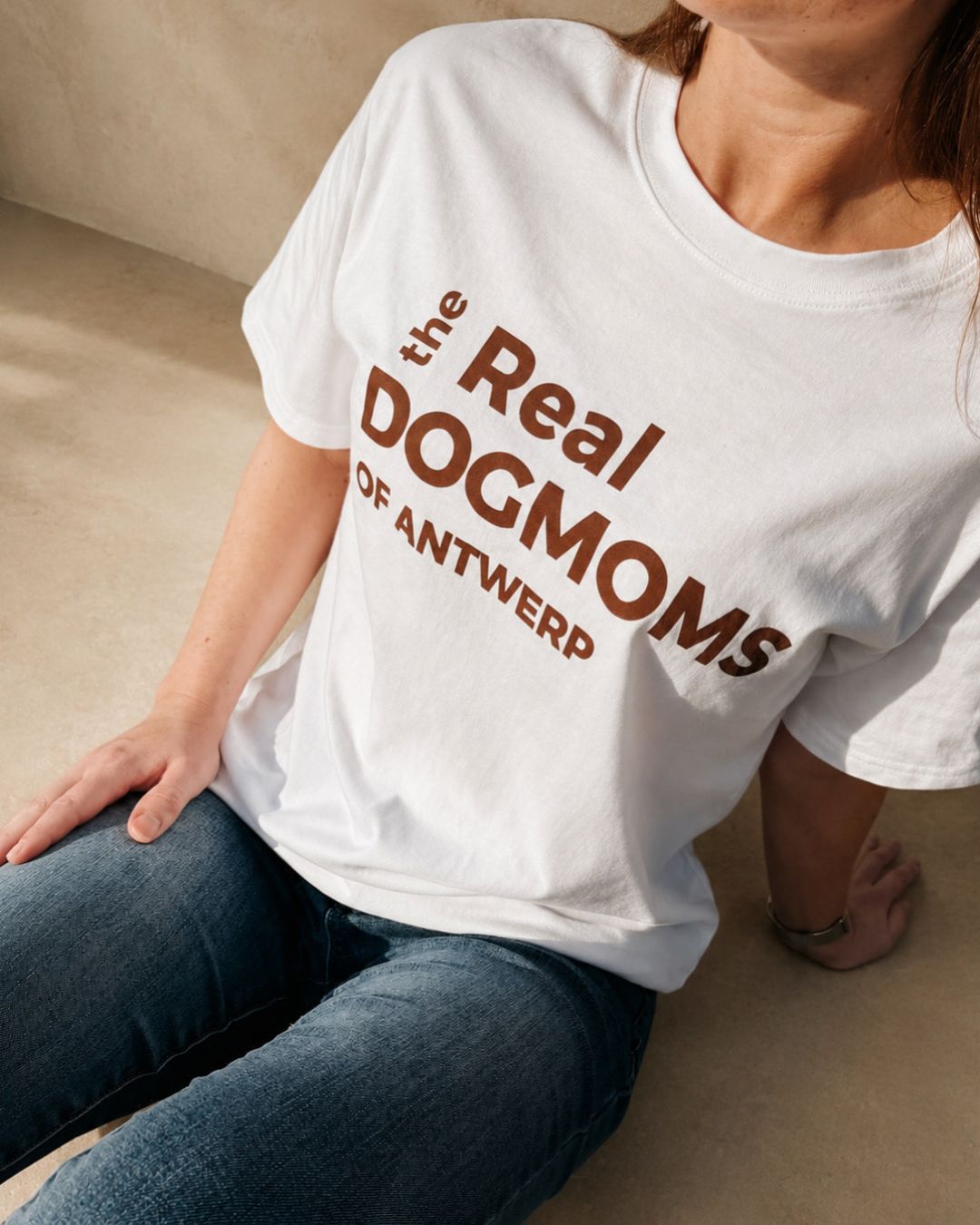 Vrouw draagt ecru The Real Dogmoms of Antwerp T-shirt met burgundy print