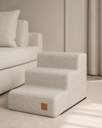 Bau Barù Trap Margot luxe hondentrap in beige naast een lichte sofa