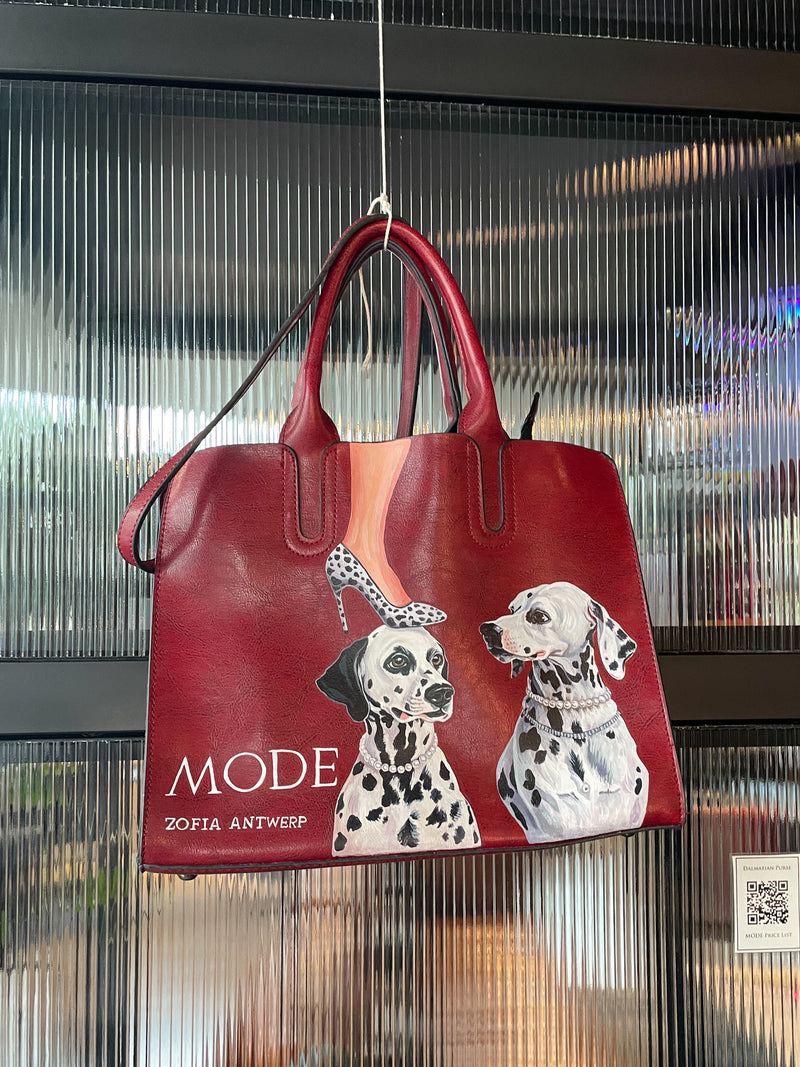 Rode handtas met geschilderde Dalmatiërs van Zofia Antwerp tijdens een kunstexpositie in Antwerpen