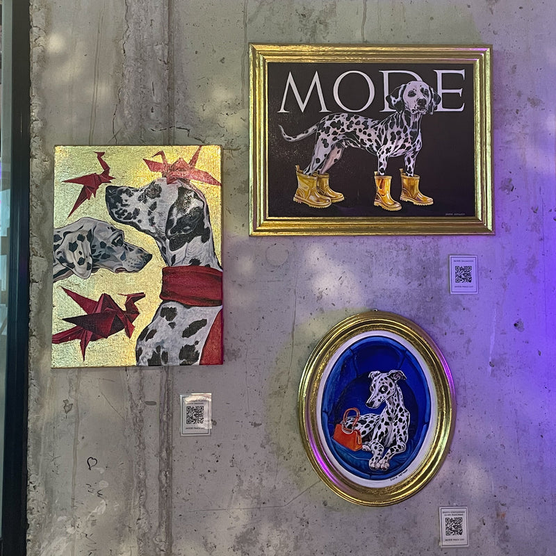 Kunstwerken met Dalmatiërs aan een betonnen muur tijdens een expositie in het Moxy Hotel Antwerpen