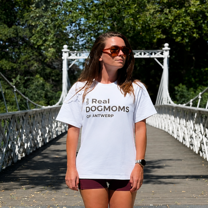 Vrouw draagt het witte The Real Dogmoms of Antwerp T-shirt op een brug in Antwerpen